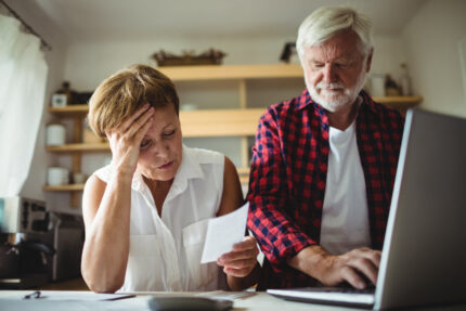 Alt text: Senior couple worried about bills.