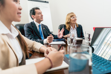 Male and female senior managers sitting down during an important interactive meeting in the conference room of a successful corporation